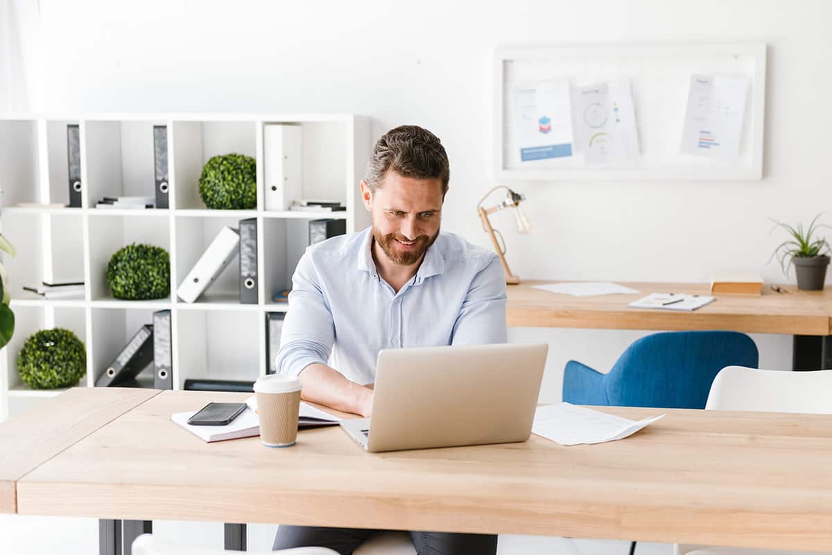 happy bearded man sitting in office working 4HVP863