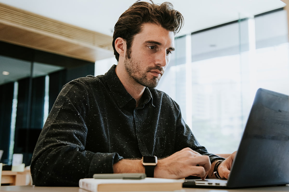 man working on a computer 8K37CBJ